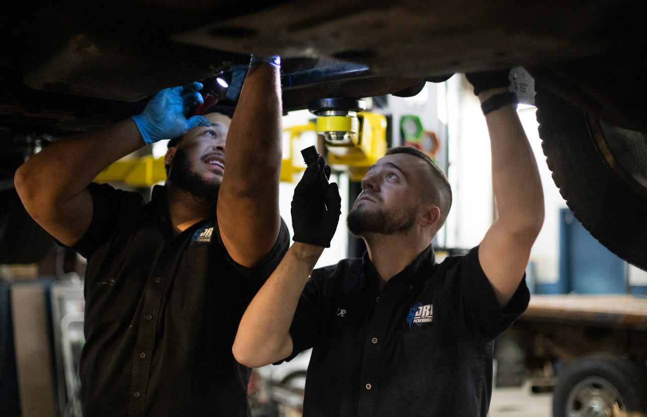 JRB employees inspecting undercarriage of vehicle